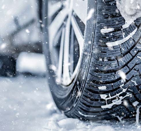 Close-up of a tire on a snow-covered winter road.